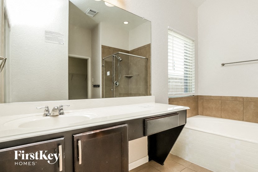 a bathroom with a large mirror and a sink and a tub
