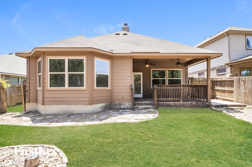 the front of a house with a deck and a yard