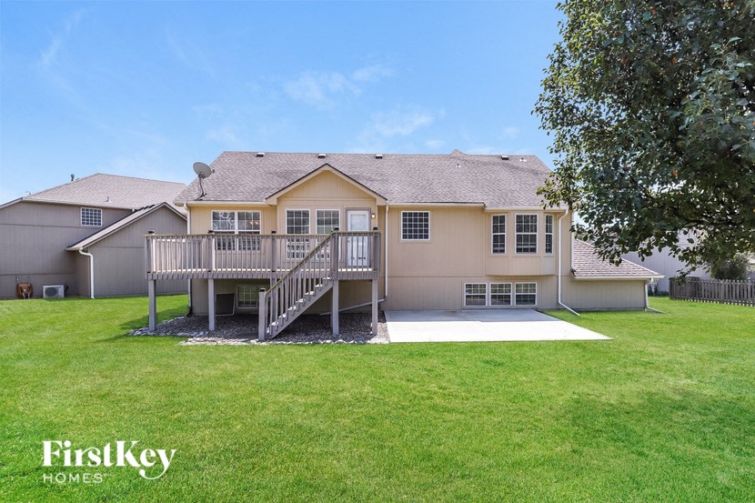 a large house with a deck and a grassy yard