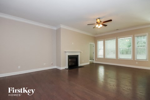 a living room with a fireplace and a ceiling fan