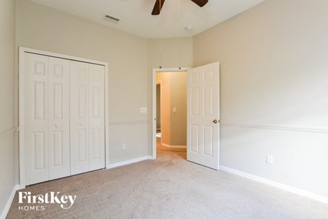 a bedroom with two white doors and a ceiling fan