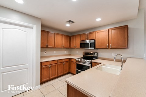 a kitchen with wooden cabinets and white counter tops and a sink