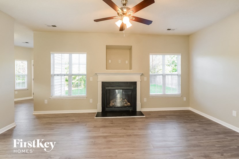 a living room with a fireplace and a ceiling fan