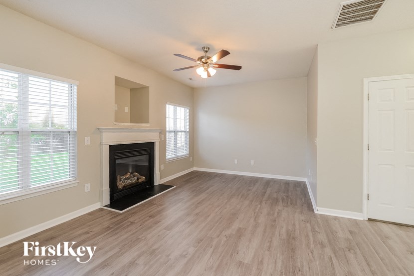 a living room with a fireplace and a ceiling fan