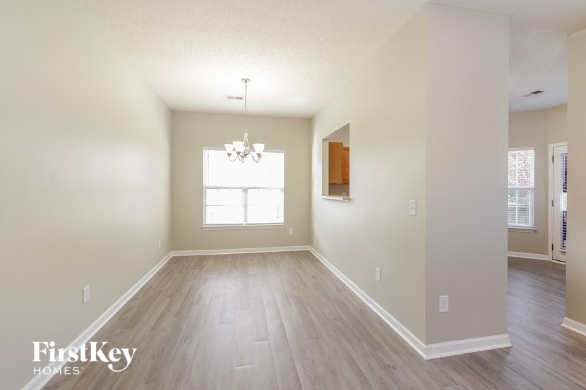 an empty living room with wood floors and a window