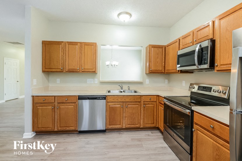 a kitchen with wooden cabinets and stainless steel appliances