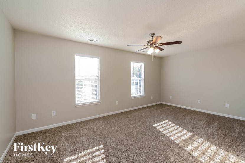 the living room of an empty home with a ceiling fan
