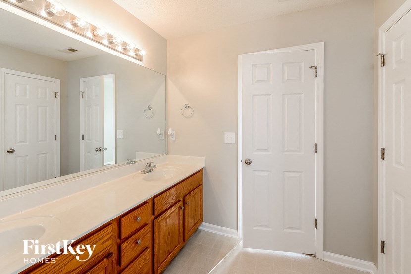 the master bathroom has a large vanity and a large mirror