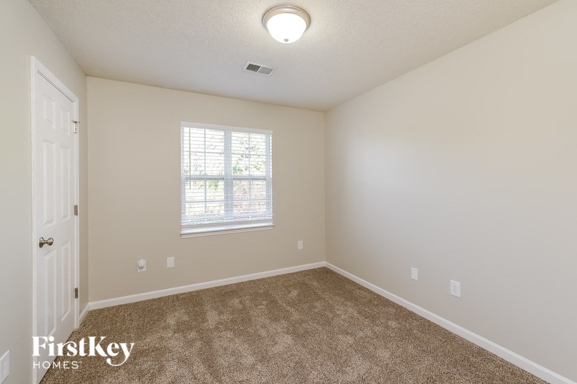 an empty room with carpet and a window