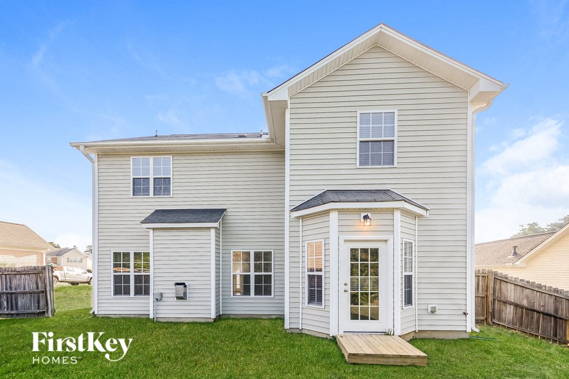 a white house with a porch and a green lawn