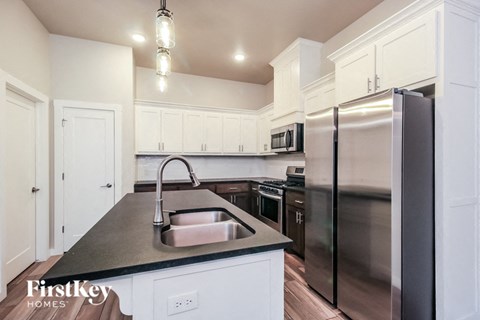 A kitchen with a sink and a refrigerator.