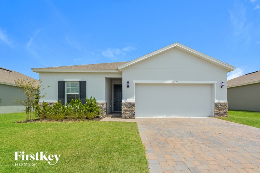 A house with a garage and a driveway in front of it.