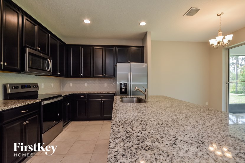 A kitchen with black cabinets and a granite countertop.