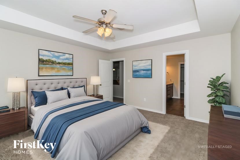 A bedroom with a large bed and a ceiling fan.