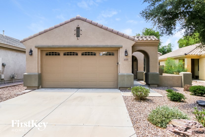 A house with a garage and a driveway in front of it.