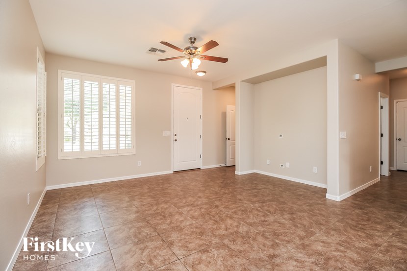 A spacious room with a ceiling fan and tiled floor.