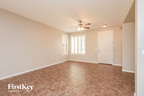 A spacious room with a ceiling fan and tiled floor.
