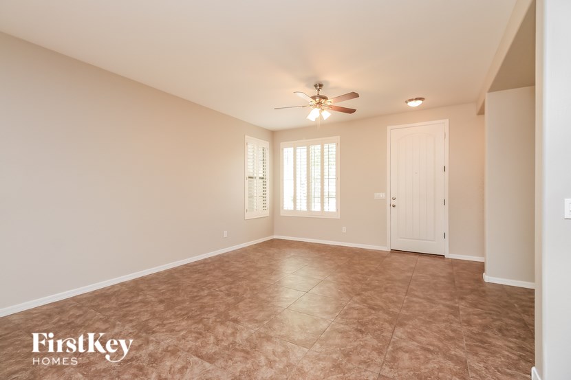 A spacious room with a ceiling fan and tiled floor.