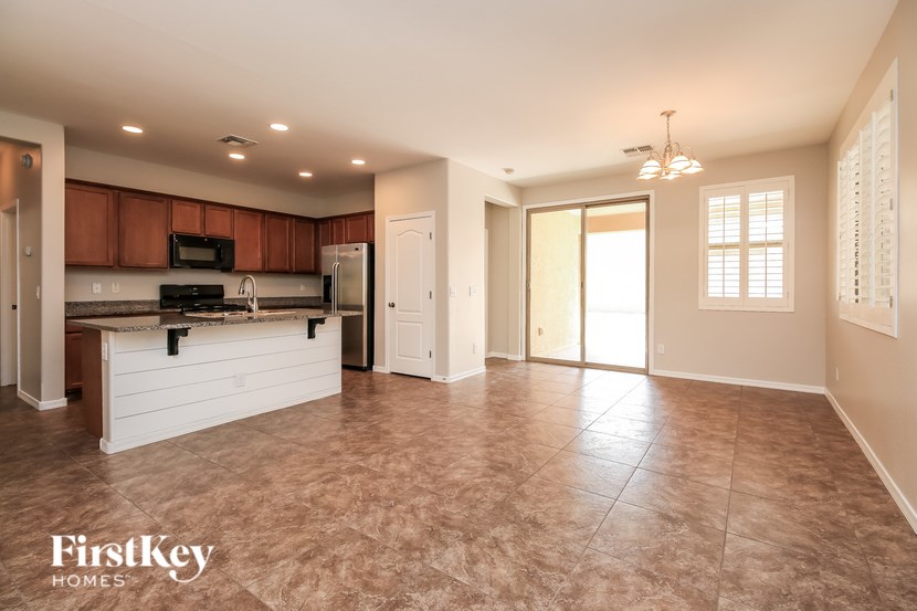 A kitchen with a refrigerator, microwave, and oven.