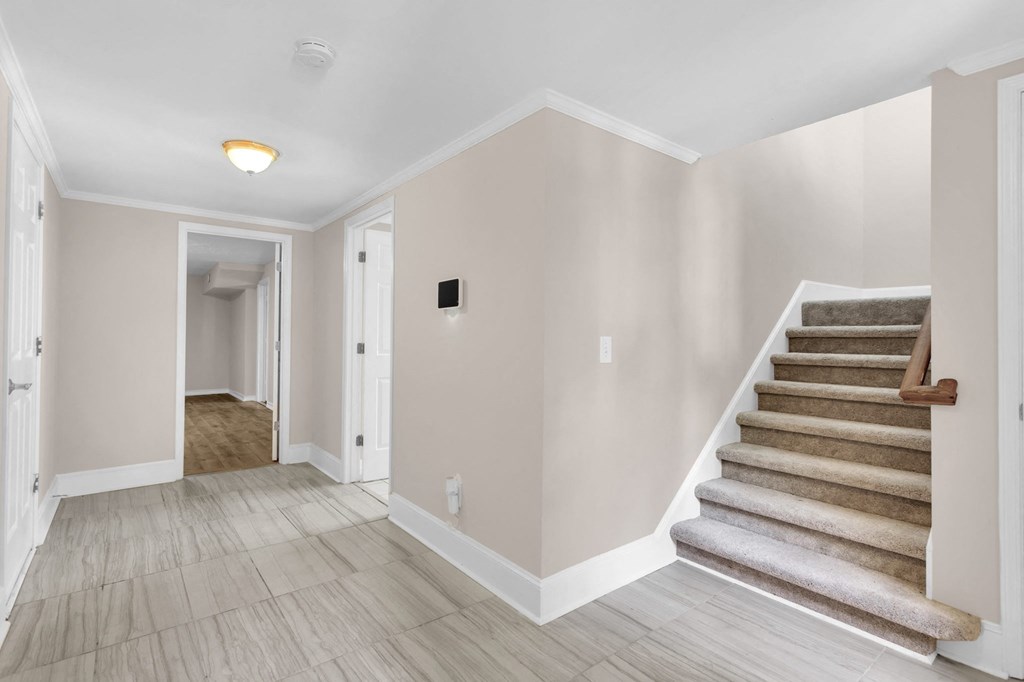 a renovated living room with a staircase and a hallway with stairs
