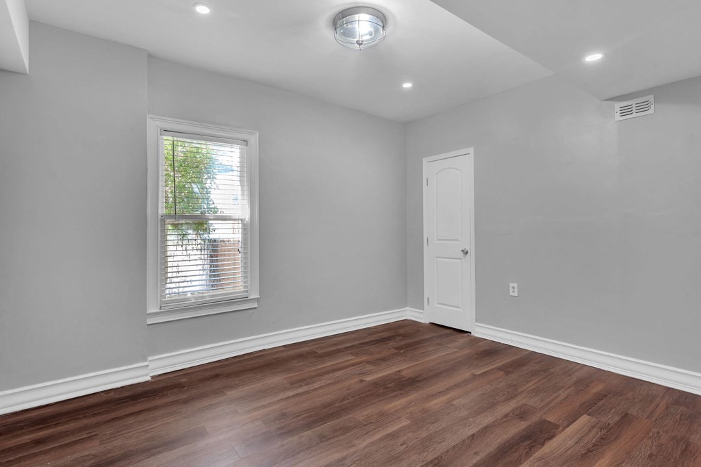a living room with wood floors and a white door