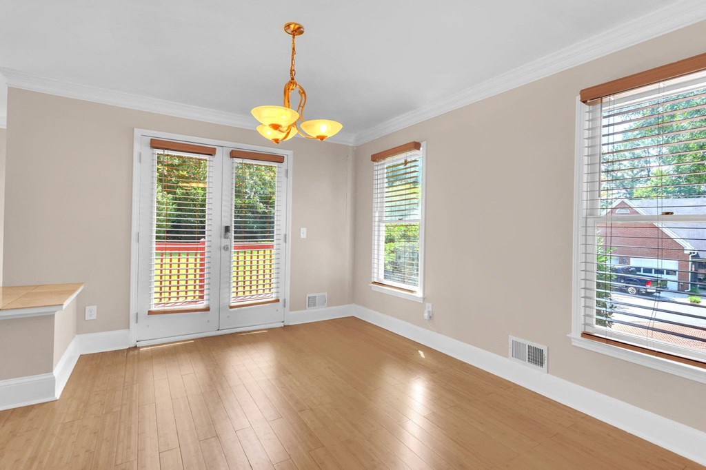 an empty living room with wood floors and windows