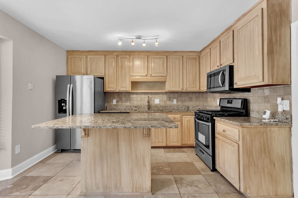 a kitchen with wooden cabinets and stainless steel appliances