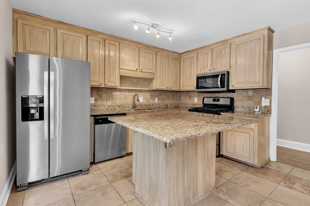 a kitchen with stainless steel appliances and a marble counter top
