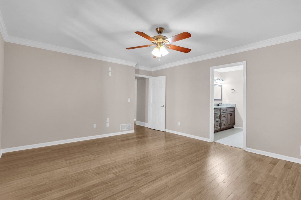 the living room is empty and has a ceiling fan