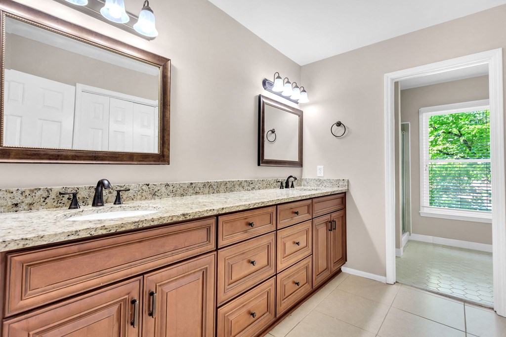 a bathroom with wooden cabinets and a sink and a mirror