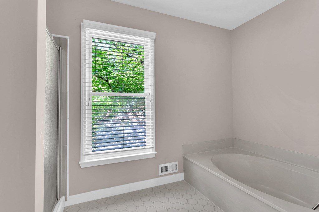 a small bathroom with a tub and a window