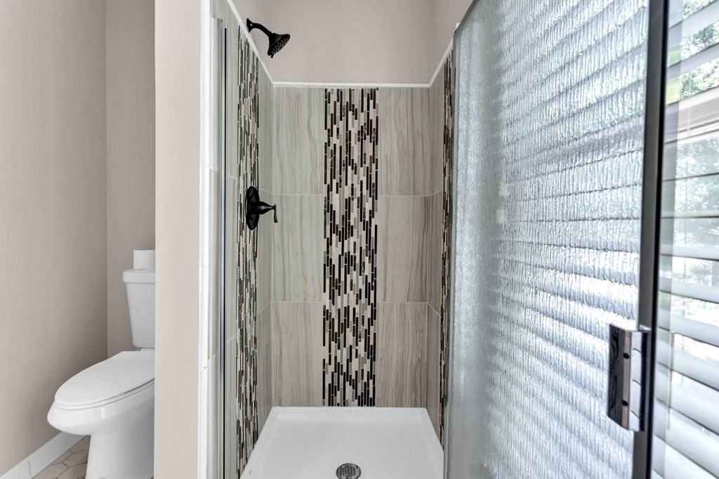 a white bathroom with a shower and a toilet