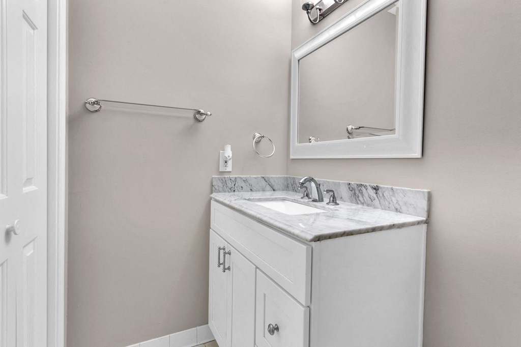 a white bathroom with a sink and a mirror