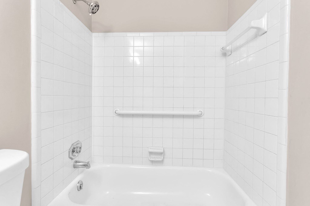 a white bathroom with a tub and a sink