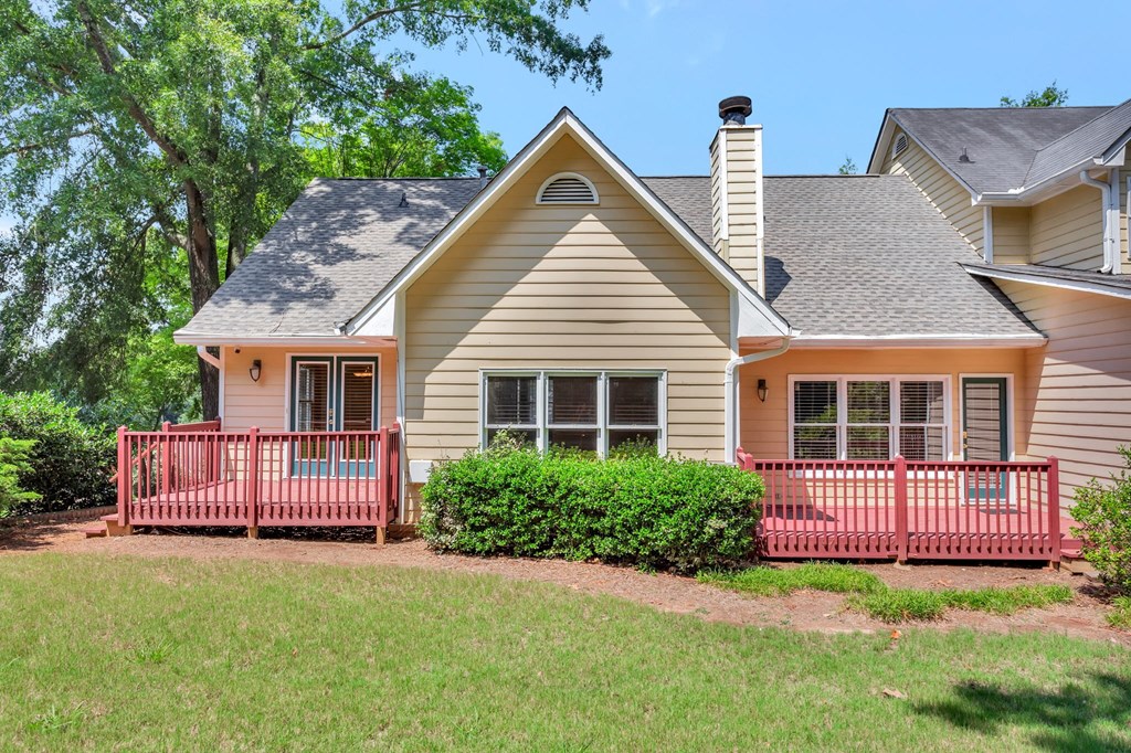 the front of a house with a porch and a red fence