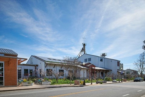 A building with a grey roof and a white wall with a red awning.
