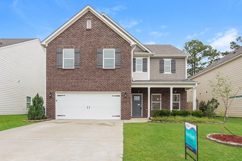 A two-story brick house with a white garage door.