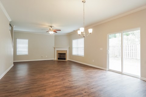 A spacious room with a fireplace and sliding glass doors.