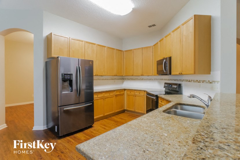 a kitchen with wooden cabinets and a stainless steel refrigerator