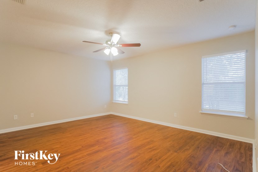 a living room with wood floors and a ceiling fan