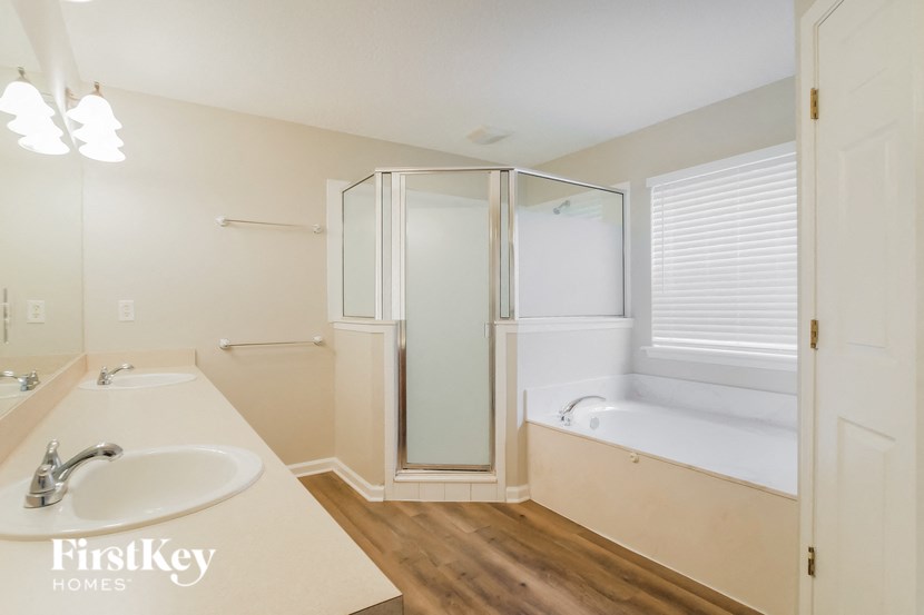 a bathroom with a sink and a shower and a bath tub