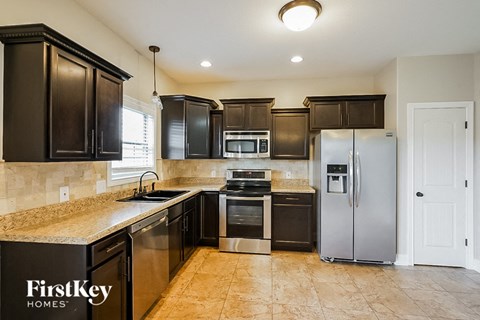 A kitchen with black cabinets and a FirstKey Homes logo.