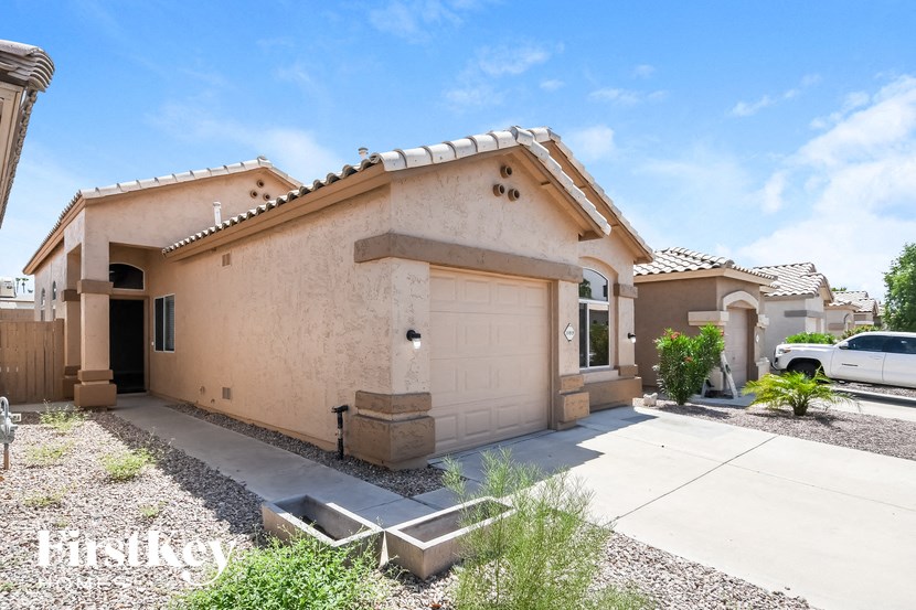 a tan house with a garage and a white door