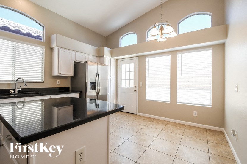 a kitchen with a black counter top and a large window