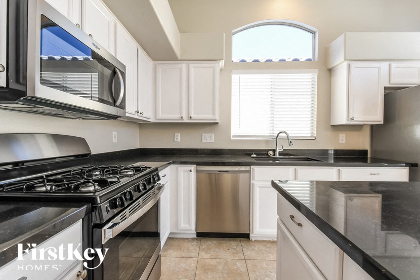 a kitchen with white cabinets and a stove and a sink