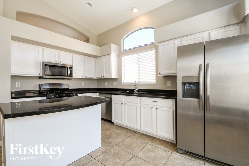 a kitchen with white cabinets and a stainless steel refrigerator