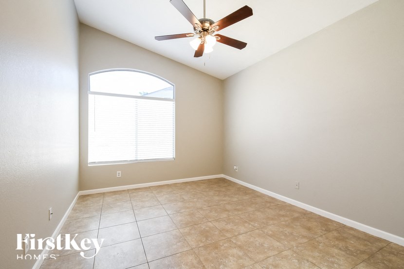 an empty room with a ceiling fan and a window