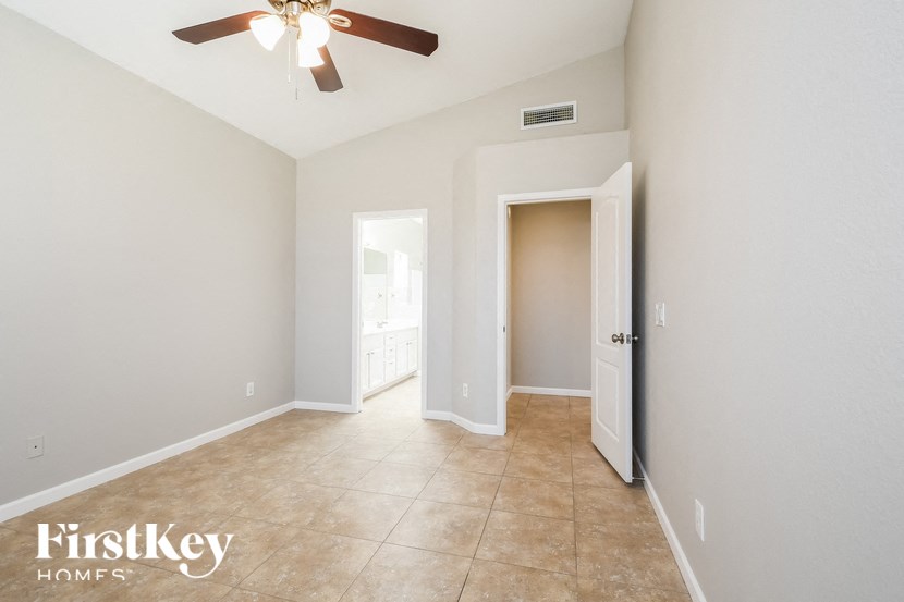 a empty room with a ceiling fan and a door to a closet