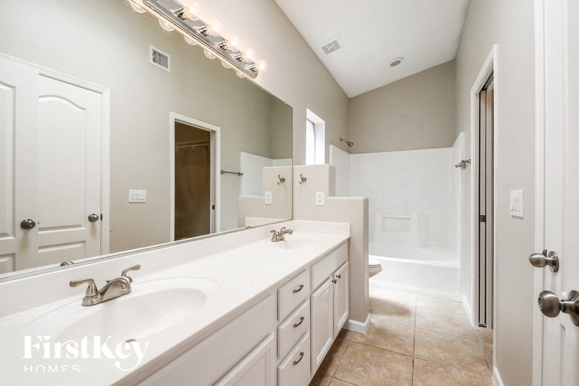 a white bathroom with a large mirror and a white sink