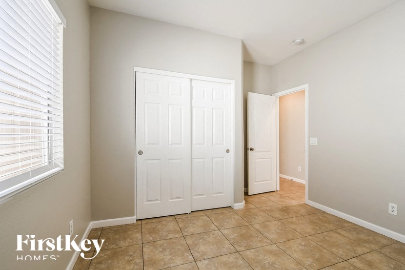a bedroom with two closets and a tiled floor